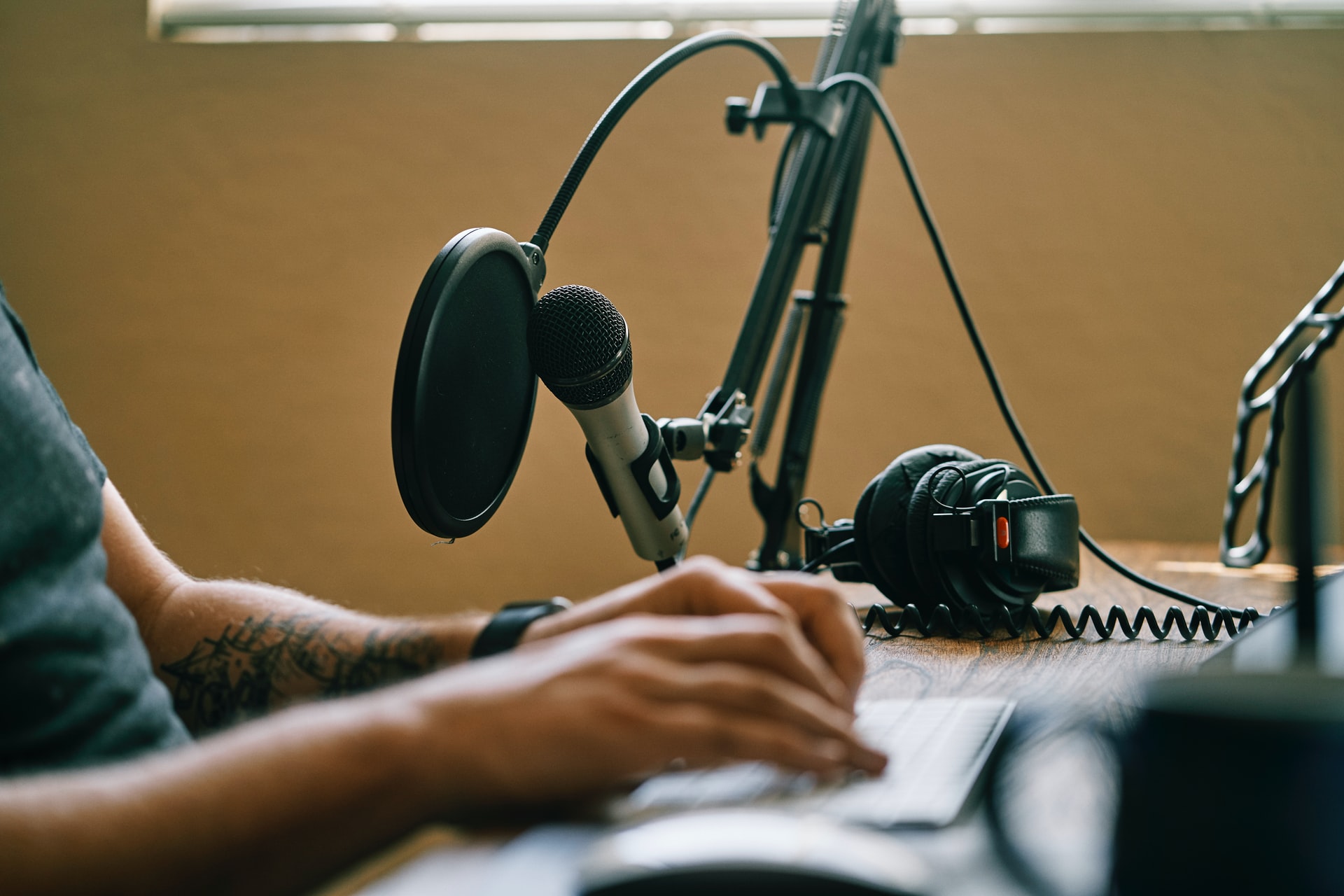 Person holding microphone on microphone stand recording a podcast