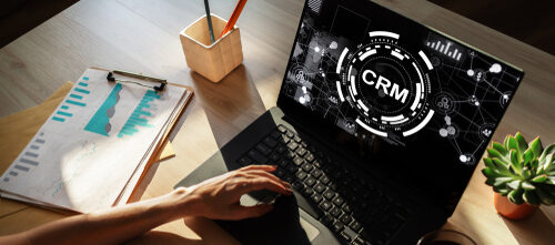 Hand on laptop viewing CRM software